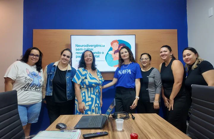 Participantes e psicóloga em um encontro do Projeto Entre Nós, na sala de reuniões do Núcleo NAPA