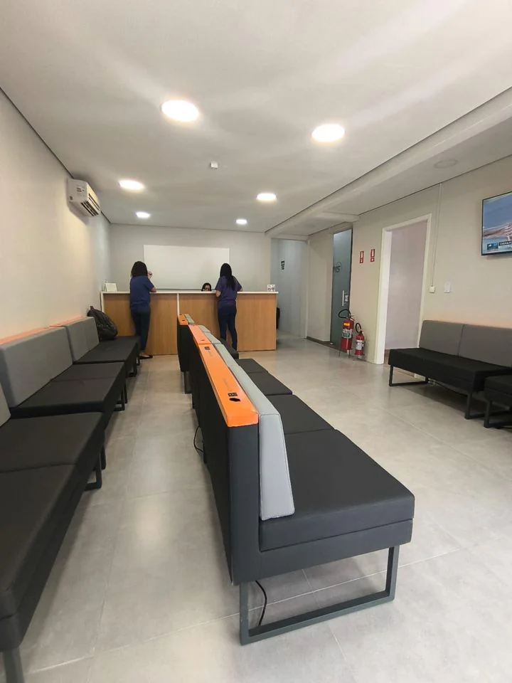 Sala de espera com bancos e balcão de atendimento