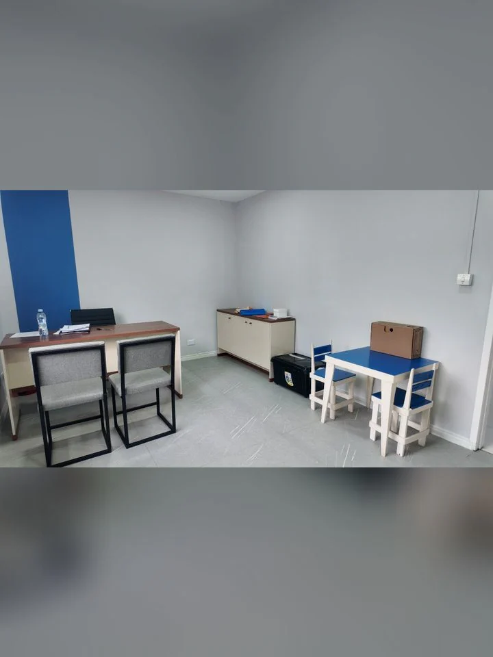 Sala de psicologia com mesa e mesinha infantil