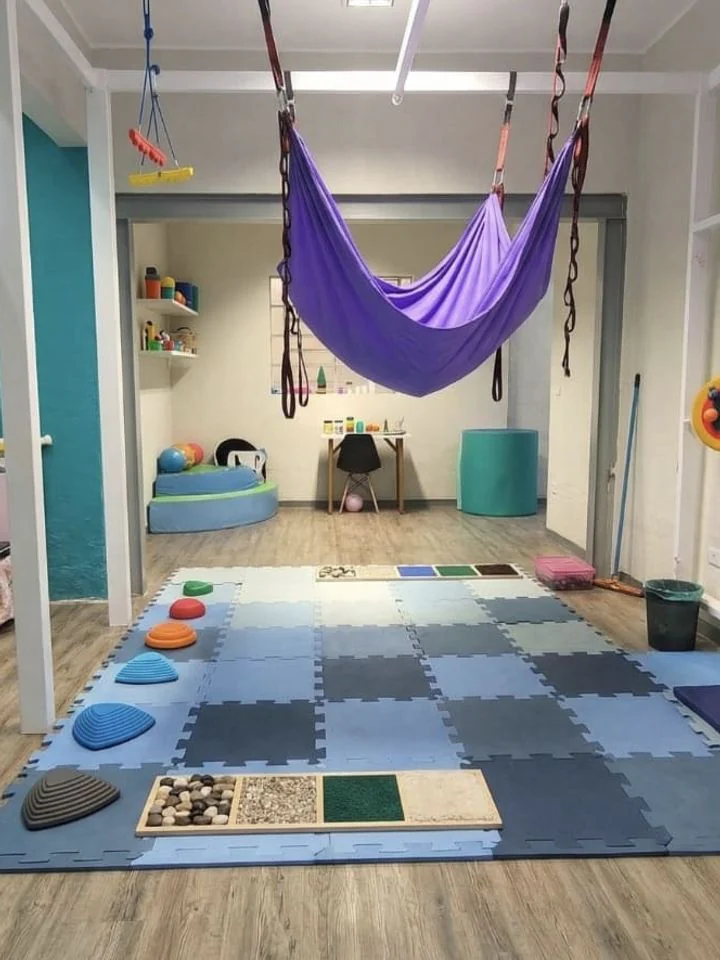 Sala de terapia ocupacional com rede suspensa e tatame
